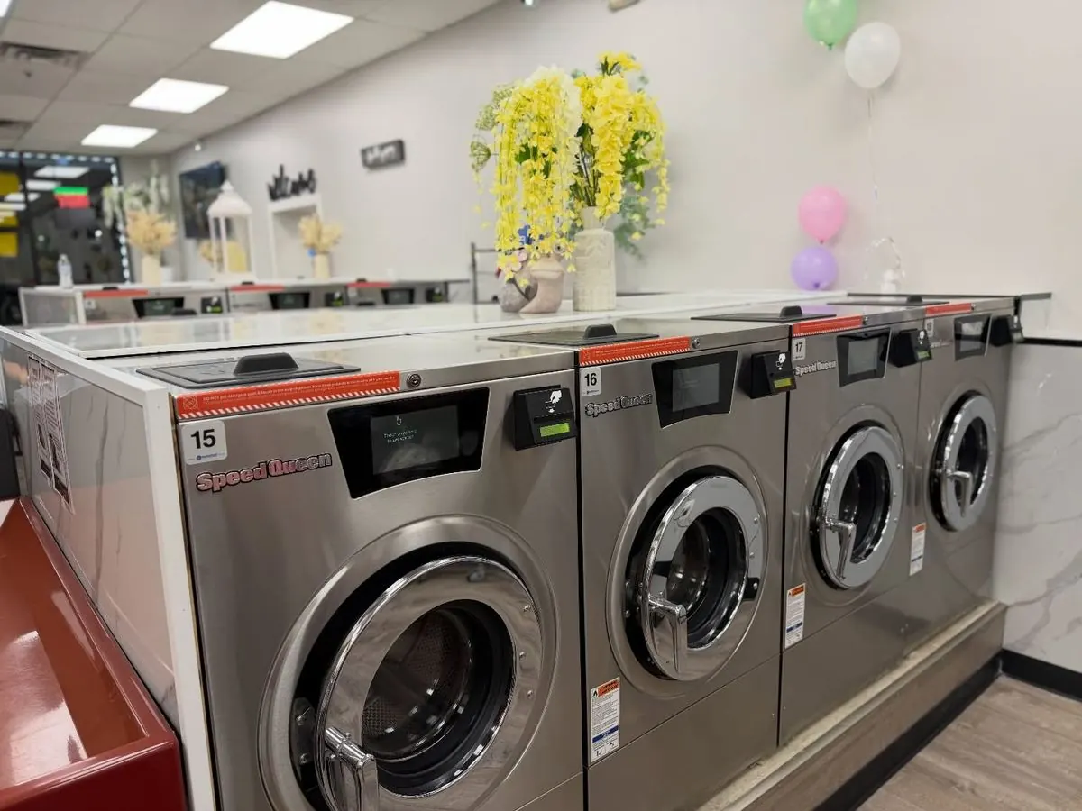 Stainless Speed Queen front-load washers along a marble counter