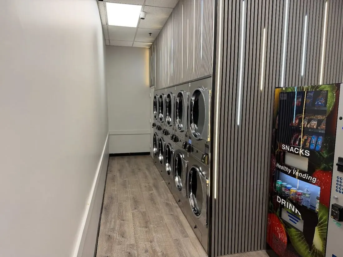 Healthy vending snack and drink machine beside a row of stacked dryers
